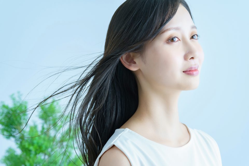 髪がなびいて笑顔の若い女性（long）